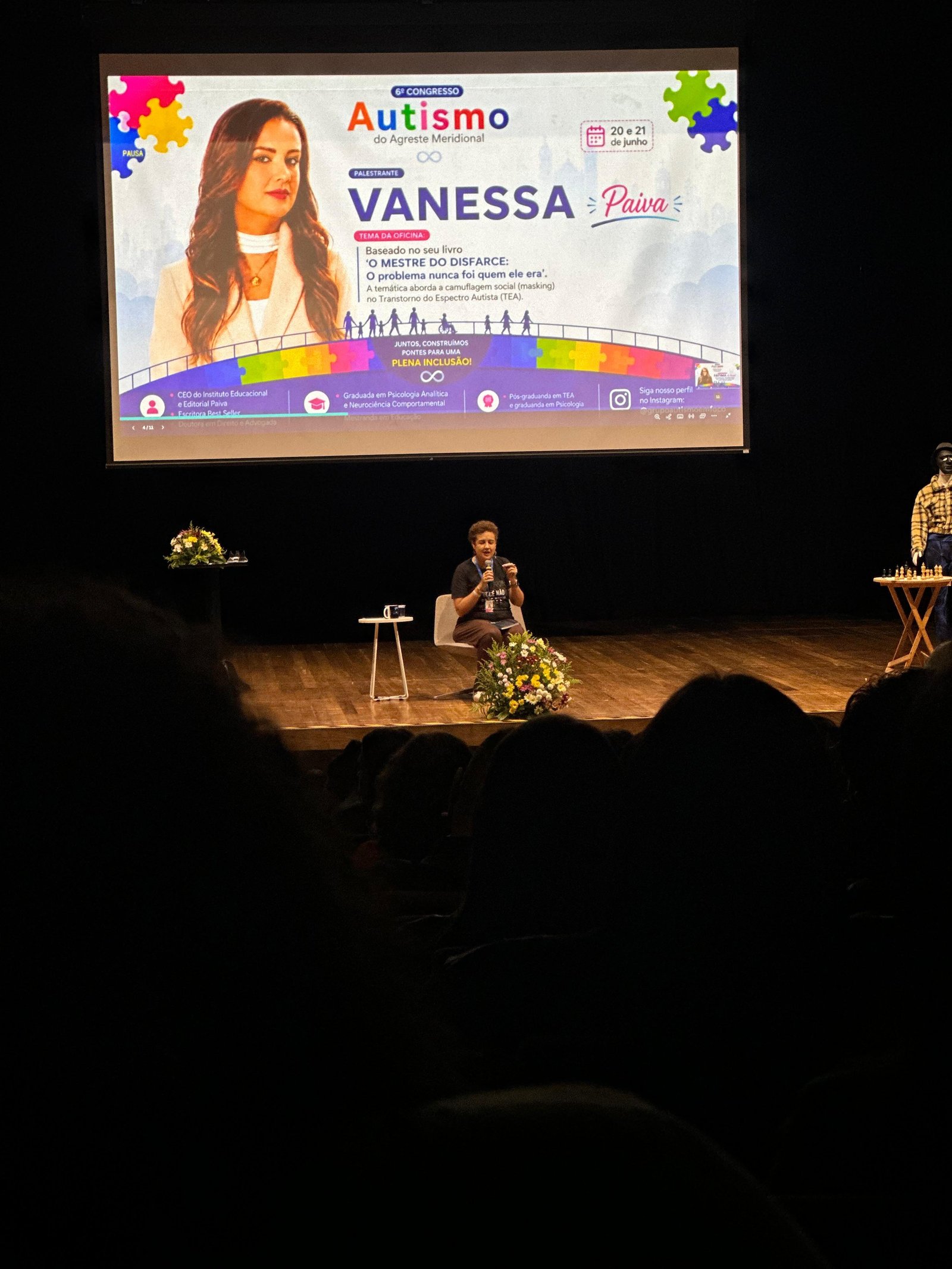 Dra. Vanessa Paiva conduzindo uma palestra no palco